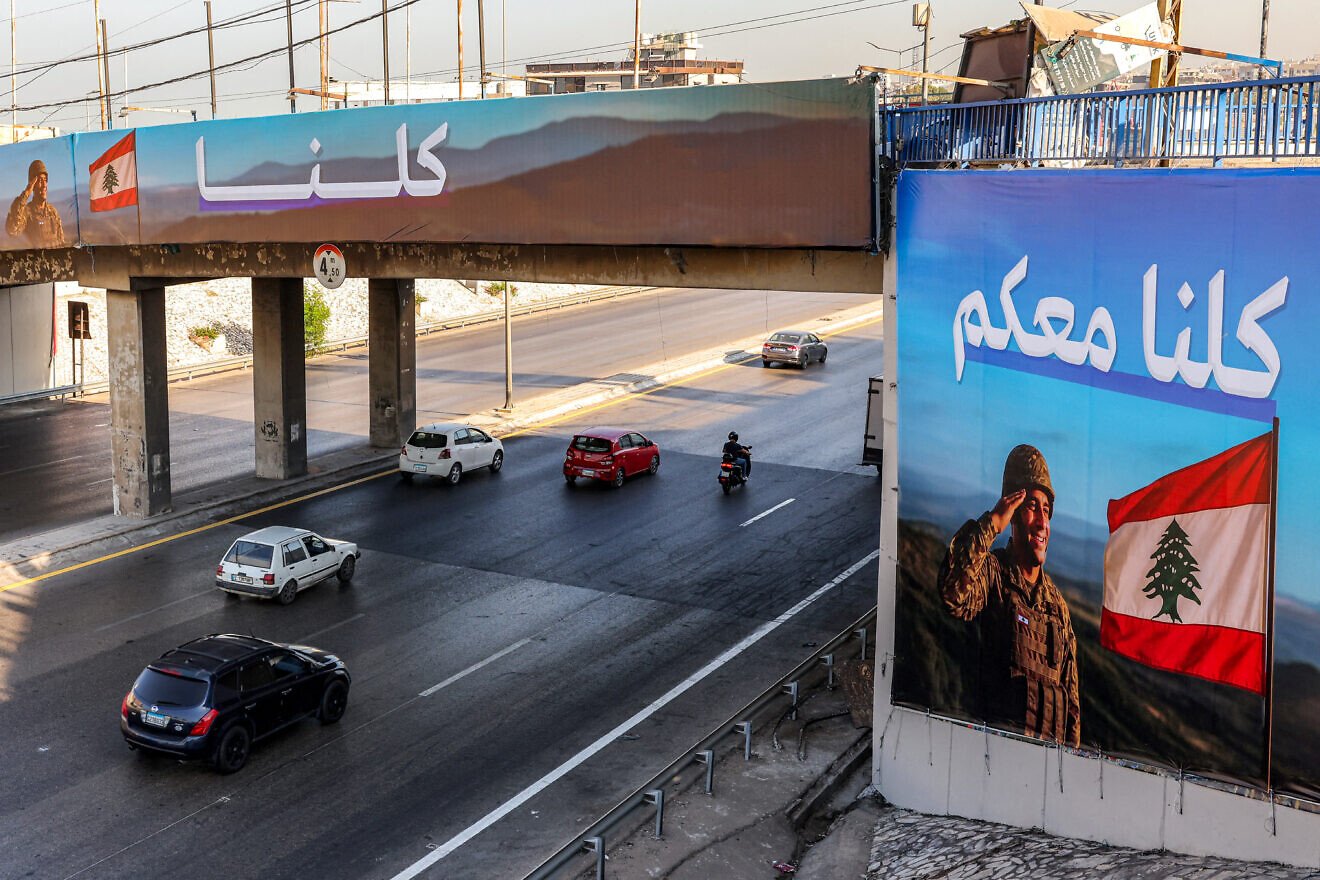 Motorists drive past billboards depicting a Lebanese army soldier saluting the national flag with the Arabic slogan "We are all with you" along the highway leading to Beirut International Airport in southern Beirut on Sept. 5, 2025. Photo by Anwar Amro/AFP via Getty Images.