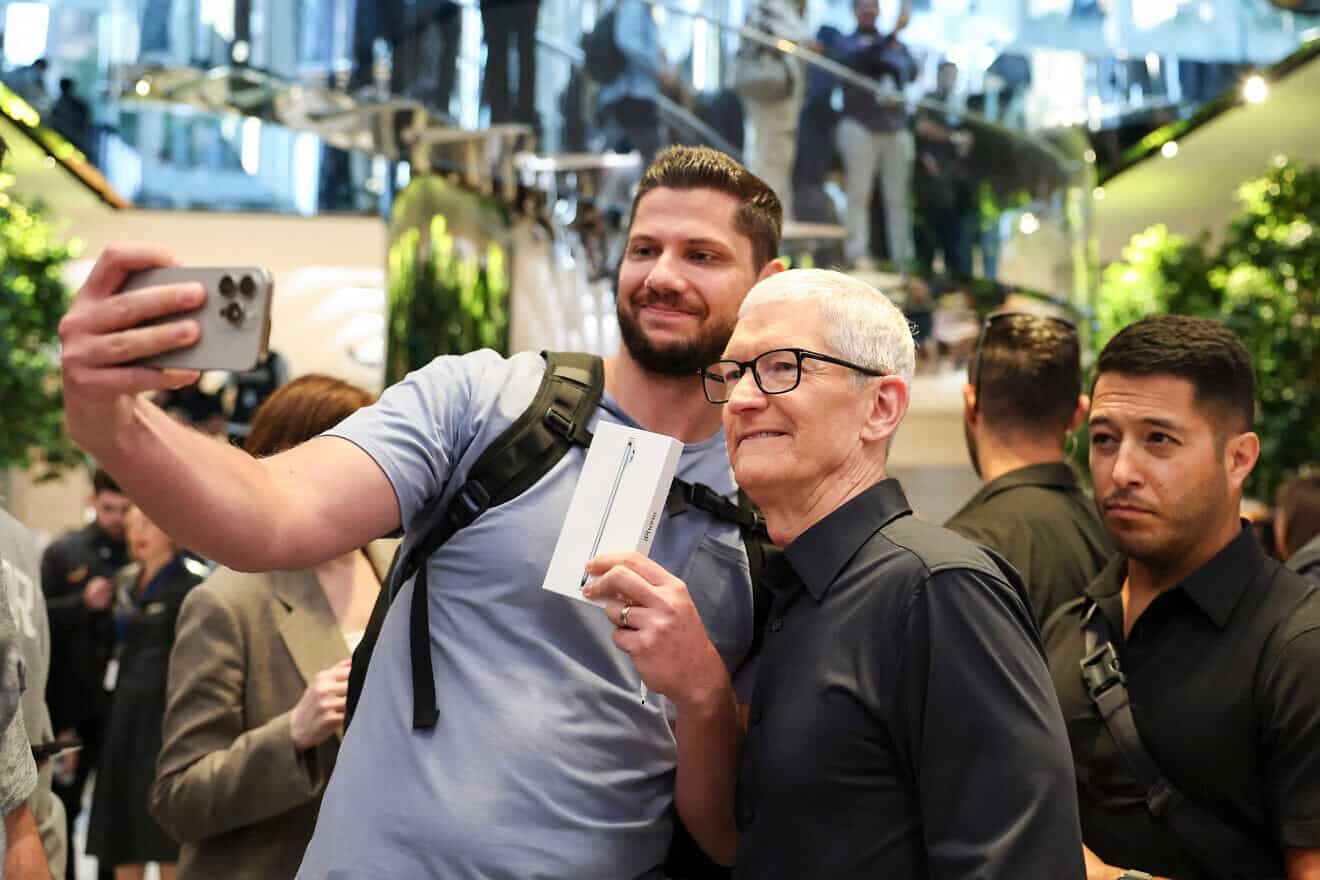 Le PDG d'Apple, Tim Cook, pose avec Keith Swiader, le premier client à faire la queue pour acheter le nouvel iPhone Air dans un Apple Store de la Cinquième Avenue à Manhattan, le 19 septembre 2025. Photo d'Angela Weiss/AFP via Getty Images.